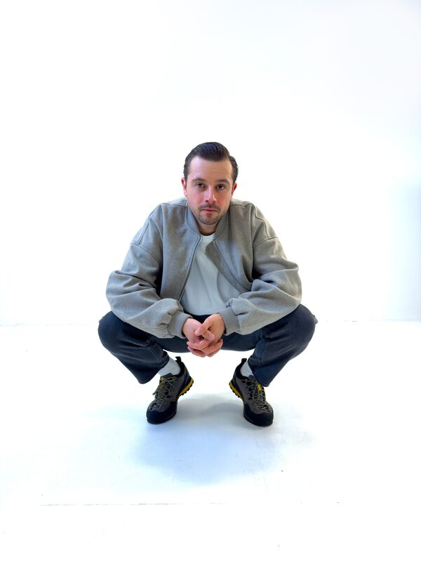 Theon Bower crouching in a white studio